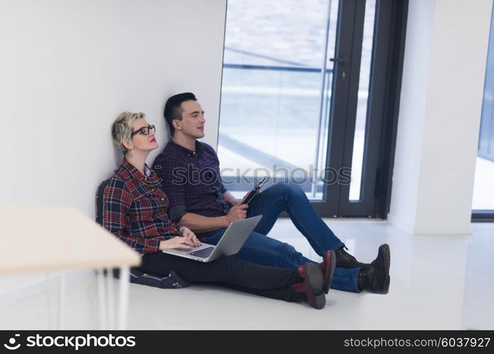 startup business and new mobile technology concept with young couple in modern bright office interior working on laptop and tablet computer on new creative project and brainstorming