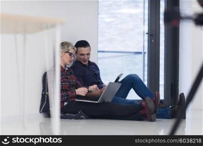 startup business and new mobile technology concept with young couple in modern bright office interior working on laptop and tablet computer on new creative project and brainstorming