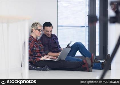 startup business and new mobile technology concept with young couple in modern bright office interior working on laptop and tablet computer on new creative project and brainstorming