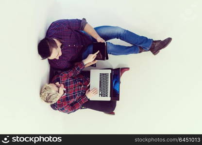 startup business and new mobile technology concept with young couple in modern bright office interior working on laptop and tablet computer on new creative project and brainstorming, aerial top view