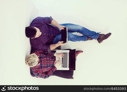 startup business and new mobile technology concept with young couple in modern bright office interior working on laptop and tablet computer on new creative project and brainstorming, aerial top view