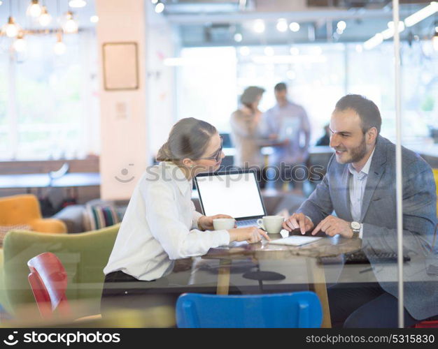 startup business people using laptop preparing for next meeting while drinking coffee and discussing ideas in creative office