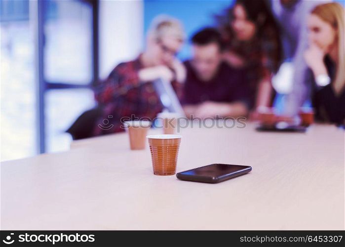 startup business team on meeting in modern bright office interior brainstorming, working on laptop and tablet computer. Smartphone on table in focus
