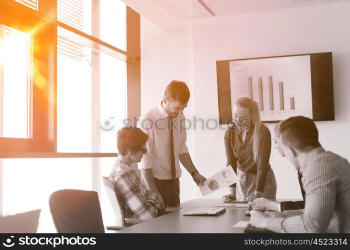 startup business young creative people group brainstorming on meeting at office using laptop and tablet computer to note ideas plans and projects sunrise or sunset with sun flare in background