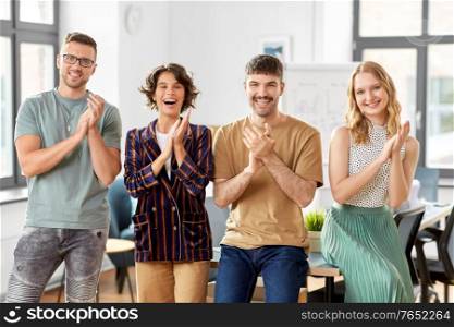 startup, corporate and people concept - happy business team applauding at office. happy business team applauding at office