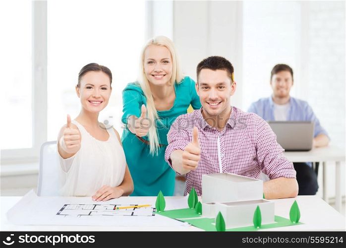 startup, education, architecture and office concept - smiling architects with house model and blueprint in office showing thumbs up