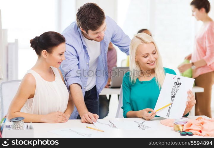 startup, education, fashion and office concept - smiling fashion designers working in office