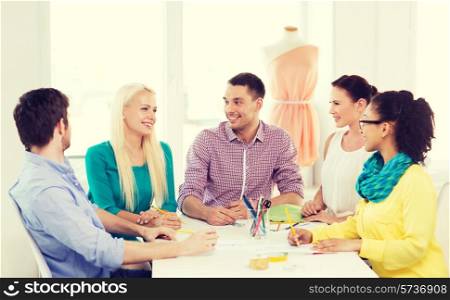 startup, education, fashion and office concept - smiling fashion designers working in office