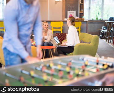 Startup Office People Enjoying Table Soccer Game During their Free Time at the creative Workplace