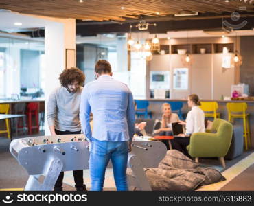 Startup Office People Enjoying Table Soccer Game During their Free Time at the creative Workplace