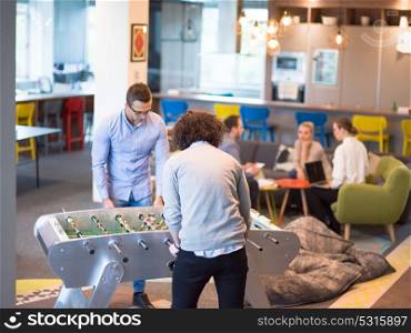 Startup Office People Enjoying Table Soccer Game During their Free Time at the creative Workplace