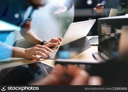 StartUp Programming Team. Website designer working digital tablet dock keyboard and computer laptop with smart phone and compact server on mable desk,light effect         