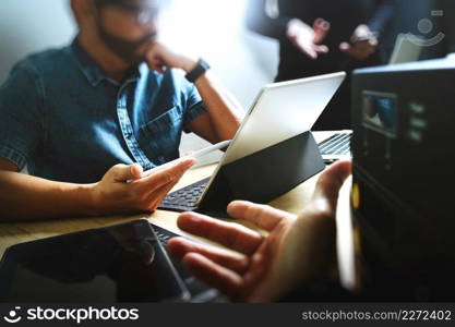 StartUp Programming Team. Website designer working digital tablet dock keyboard and computer laptop with smart phone and compact server on mable desk,light effect