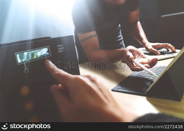 StartUp Programming Team. Website designer working digital tablet dock keyboard and computer laptop with smart phone and compact server on mable desk,light effect