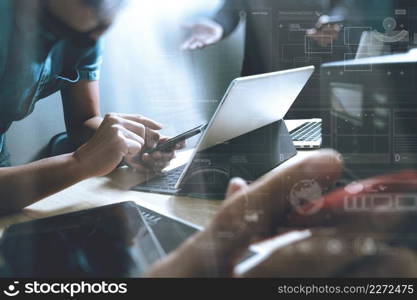 StartUp Programming Team. Website designer working digital tablet dock keyboard and computer laptop with smart phone and compact server on mable desk,light effect