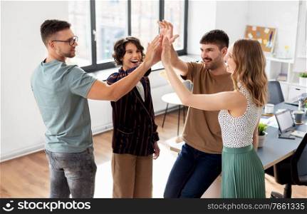 startup, success and people concept - happy business team making high five at office. happy business team making high five at office