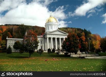 State Capitol in the fall with blue sky & colorful trees in the background, Montpelier, Vermont