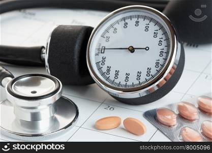 Statins or generic medicines on a calendar with a sphygmanometer and stethoscope. Medical check up concept.