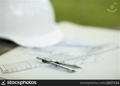 Stationary and a white hard hat on concrete outdoors