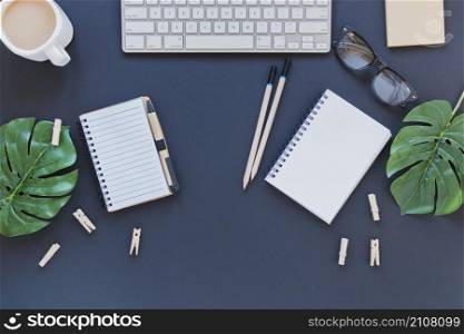 stationery near keyboard coffee cup table with leaves