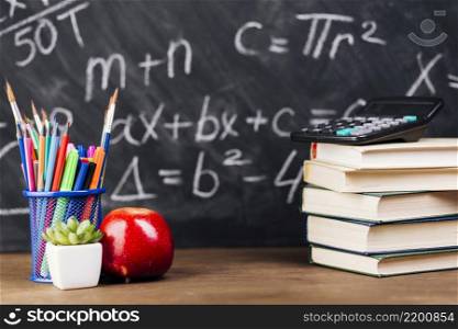 stationery stacked books placed desk chalkboard background