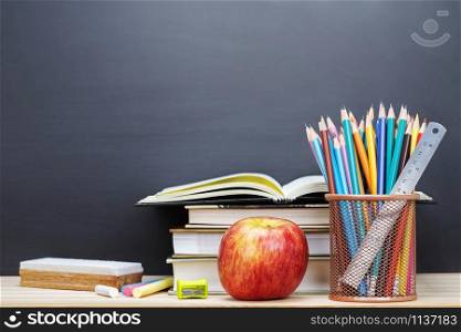 Stationery Supplies and accessories color Chalk,Crayon,eraser, Pencil,Ruler,apple red, book, put on the desk wood stationery blackboard blank in Classroom background. Education back to school concept