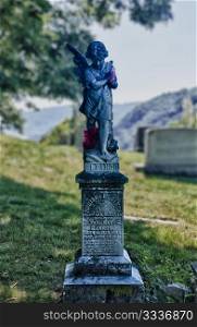 Statue above grave of dead girl in 1893 in Harpers Ferry with flowers in remembrance