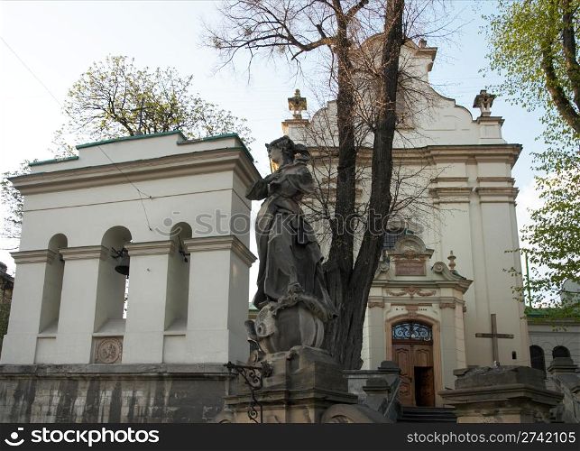 Statue and belfry near Saint Antony church in Lviv City, Ukraine