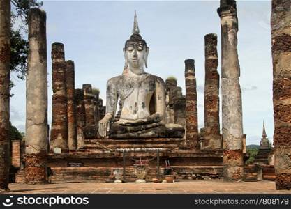 Statue Buddha and brick columns in wat Mahathat, Sukhotai, Thailand