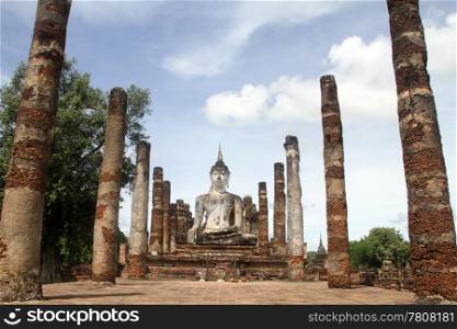 Statue Buddha and brick columns in wat Mahathat, Sukhotai, Thailand