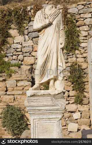 Statue in front of a stone wall, Ephesus, Turkey