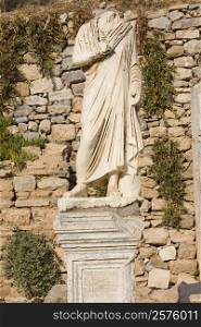 Statue in front of a stone wall, Ephesus, Turkey