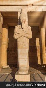 Statue in Hatshepsut temple under morning sunbeams, Egypt. Statue in Hatshepsut temple