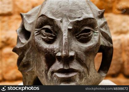 Statue of a old man's head on dark stone