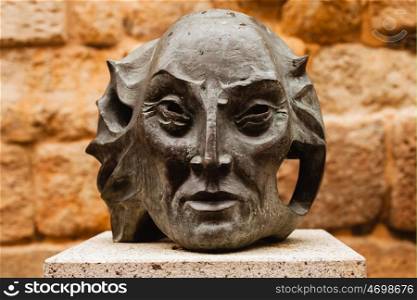 Statue of a old man's head on dark stone