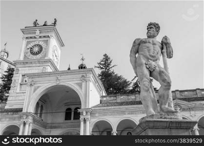 Statue of Caco, the clock tower in the background. Udine Friuli Italy