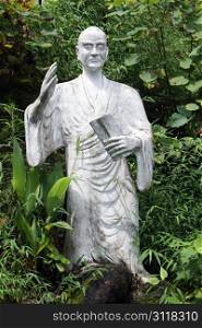 Statue of chinese buddhist holy man and tree