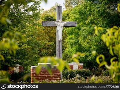 Statue of Christ being crucified on cross in stations of the cross in garden