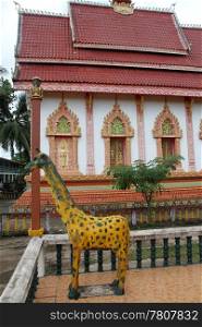 Statue of giraffe and old buddhist templ;e in Vientiane, Laos