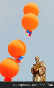 Statue of Hugo Grotius with balloons on Queens Day.