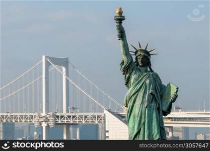 Statue of Liberty and rainbow bridge in Odaiba, Tokyo, Japan.