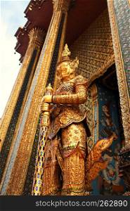 Statue of the golden guard at an entrance to the Phra Mondop temple