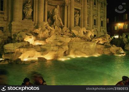 Statues at a fountain lit up at night, Trevi Fountain, Rome, Italy