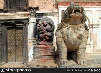 Statues near wooden door of Art museum in Bhaktapur in Nepal