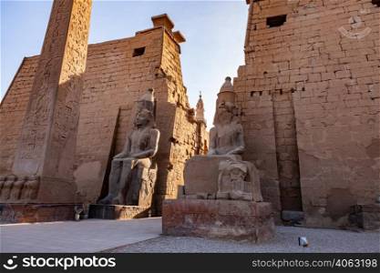 Statues of Pharaoh Ramses II and obelisk at the first pylon of Luxor Temple complex in Luxor, Egypt.