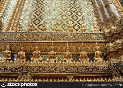 Statues on the wall of temple in Grand palace, Bangkok, Thailand