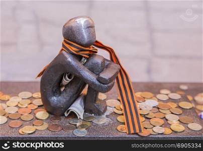 Statuette boy kotoryts looks at the moon and coins around
