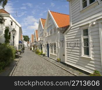 Stavanger Wood House, typical architecture or norweigan style, with a tourist cruise at background. Gamle Stavanger (&rsquo;Old Stavanger&rsquo;) is an area of the city of Stavanger in the county of Rogaland, Norway, and is believed to be EuropeOs largest collection of wooden buildings. The area includes the Norwegian Canning museum which displays a typical factory from the 1920&rsquo;s.