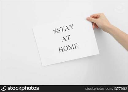 stay at home concept. woman hand holding paper with words stay at home isolated on white background. Coronavirus, COVID-19, self-quarantine, isolation.. stay at home concept. woman hand holding paper with words stay at home isolated on white background. Coronavirus, COVID-19, self-quarantine, isolation