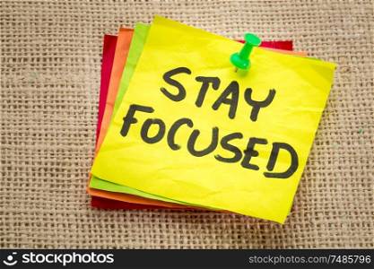 stay focused reminder on a sticky note - motivation concept